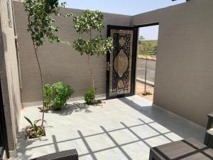 eine offene Tür zu einem Haus mit einer Terrasse in der Unterkunft شاليهات ليالي العقيق in Al Aqiq