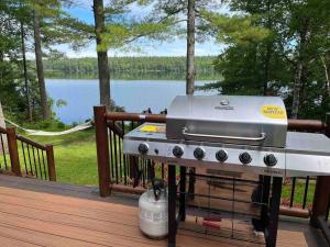 a grill on a deck with a view of a lake at Macwan's Lakefront Cottage in Calabogie