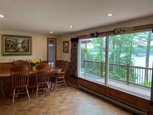a dining room with a table and a large window at Macwan's Lakefront Cottage in Calabogie