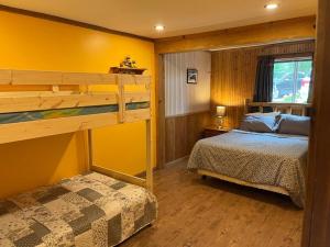 1 dormitorio con 1 litera y 1 litera en Macwan's Lakefront Cottage en Calabogie