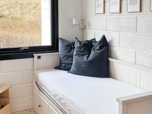 a bench in a tiny house with pillows on it at Beachfront Bliss in Vesterhavet - By Traum Ferienwohnungen in Vrist