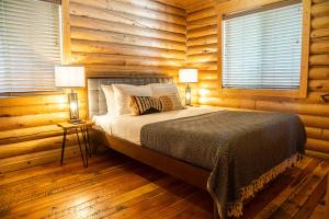 a bedroom with a bed in a log cabin at High Creek Lodge and Cabins in Pagosa Springs