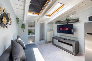 a living room with a tv and a couch at Free Parking Tiny House Wifi Netflix 15 Minuti dal Duomo in Milan