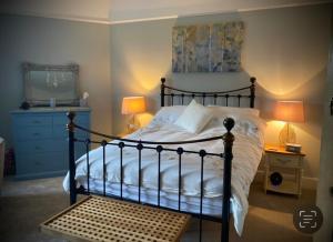 a bedroom with a bed and two lamps and a dresser at The Old Rectory with Valley View in Stockton on Teme