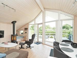 uma sala de estar com um sofá, uma mesa e cadeiras em Holiday home Slagelse XLVII em Slagelse