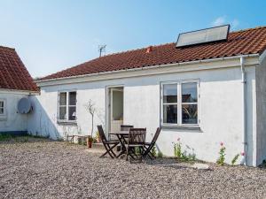 una casa blanca con una mesa y sillas frente a ella en Holiday home Lemvig XLIII en Lemvig