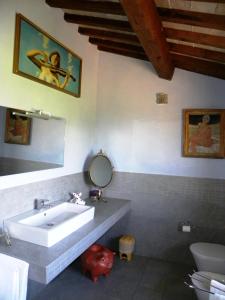 a bathroom with a sink and a toilet and a mirror at Appartamenti Verde Collina Umbra in Bevagna