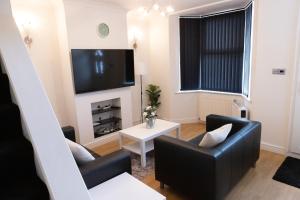 een woonkamer met 2 stoelen en een flatscreen-tv bij Gillingham Two bedroom house with garden and free parking in Gillingham