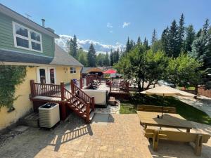 a patio with a table and benches and a house at Blaeberry Valley Vacation Rentals in Golden