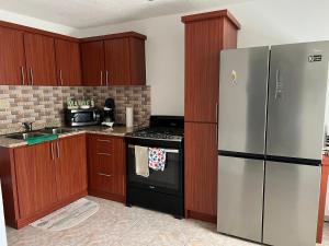 una cocina con electrodomésticos de acero inoxidable y armarios de madera en Casita Nieves, en Isabela