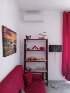 - un salon avec un canapé rouge et une lampe dans l'établissement La Magnolia a 500mt dal mare, à Marina di San Vito