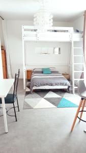 - une chambre avec des lits superposés, une table et des chaises dans l'établissement Maison de ville calme, à La Roche-sur-Yon
