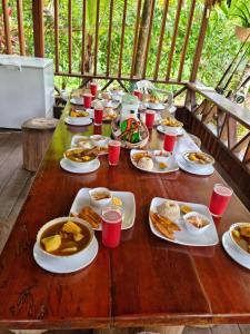 una mesa de madera con platos de comida. en Cabañas las perlas en Bahía Solano