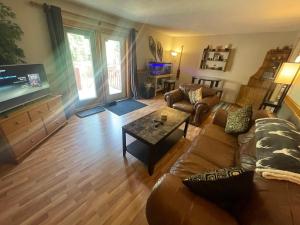 a living room with a couch and a tv at Blaeberry Valley Vacation Rentals in Golden