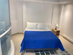 ボゴタにあるAparta Hotel Montealegreのベッドルーム1室(青い毛布付きのベッド1台付)