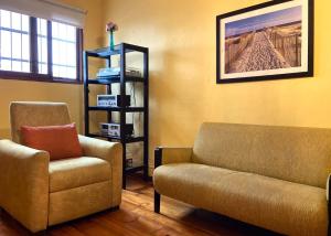 een woonkamer met een bank en een stoel bij R° | 1BR apartment infront Chorrillos Sea in Lima