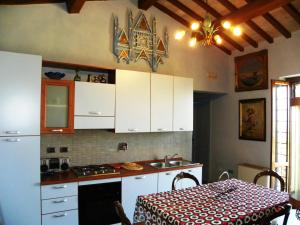 a kitchen with white cabinets and a table with a table cloth at Appartamenti Verde Collina Umbra in Bevagna +56 photos