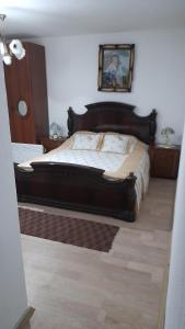 una camera con un grande letto con struttura in legno di Etno kuca Petrovic a Štrpce