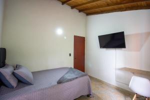 um quarto com uma cama e uma televisão na parede em Apartamento a 3 min del Hospital Pablo tobón uribe em Medellín