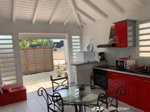 a kitchen with red cabinets and a table and a table and a kitchen with at Bungalow Little Garden in Mahaudière