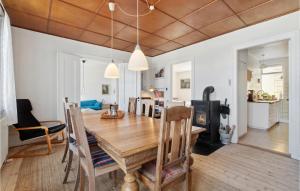 comedor y sala de estar con mesa de madera en 3 Bedroom Gorgeous Home In Gudhjem, en Gudhjem