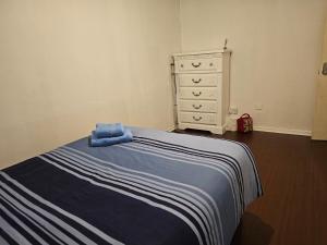 a bed with a blue blanket and a dresser in a room at Axel room 2 in Manchester