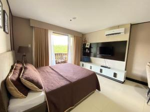 a hotel room with a bed and a television at Crosswinds Nature View Suite in Tagaytay