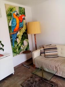 a living room with a couch and a painting on the wall at Most sunny days on Gran Canaria in Puerto Rico de Gran Canaria