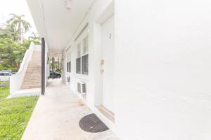 a white house with a door and a sidewalk at Fort Lauderdale Studio - 5 minutes walking to Las Olas Beach in Fort Lauderdale