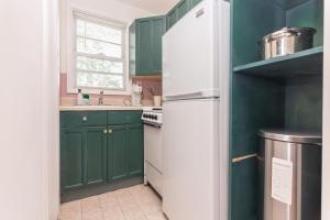a kitchen with green cabinets and a white refrigerator at Fort Lauderdale Studio - 5 minutes walking to Las Olas Beach in Fort Lauderdale