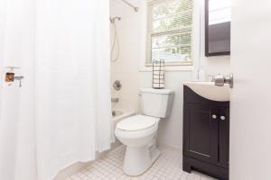 a white bathroom with a toilet and a sink at Studio Las Olas Beach - Fort Lauderdale - 5 minutes walk to beach in Fort Lauderdale