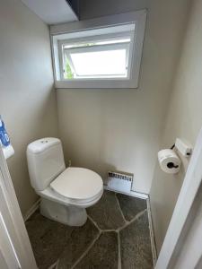 uma pequena casa de banho com um WC e uma janela em Koselig og stor enebolig til leie i Arendalsuke / ferie em Arendal