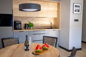 una cocina con una mesa de madera con sandías. en Apartament Opal - Family & SPA en Dziwnów