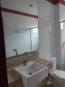 La salle de bains blanche est pourvue d'un lavabo et de toilettes. dans l'établissement Casa na Serra. Negócios ou lazer, à Serra