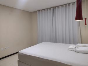 um quarto branco com uma cama branca e um candeeiro vermelho em Casa na Serra. Negócios ou lazer em Serra