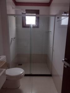 uma casa de banho com uma cabina de duche em vidro e um WC. em Casa na Serra. Negócios ou lazer em Serra