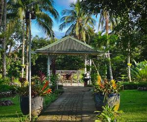 un jardín con cenador y algunas plantas en BALAI BANAHAW Vacation Farm and Private Resort en Lucban