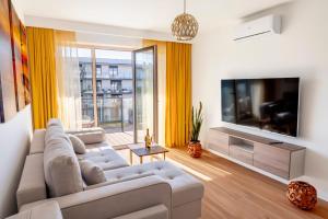 ein Wohnzimmer mit einem Sofa und einem Flachbild-TV in der Unterkunft Apartament Opal 34 Family & SPA in Dziwnów