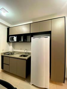 a kitchen with a refrigerator and a sink at Studio APaulistana56 in Sao Paulo