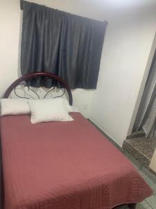 1 dormitorio con 1 cama con manta roja y ventana en Alojamiento Morelos, en Ciudad de México