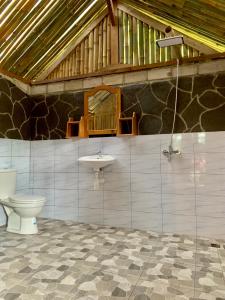 bagno con servizi igienici e lavandino di The Alam Tetebatu Bungalow & Restaurant a Tetebatu