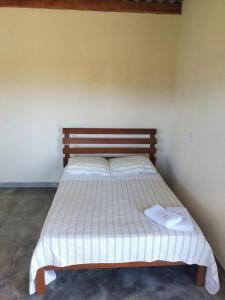 a bedroom with a bed with two towels on it at Chalé pôr do Sol in Alto Paraíso de Goiás