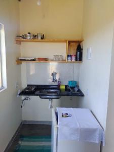 a small kitchen with a counter and a stove at Chalé pôr do Sol in Alto Paraíso de Goiás