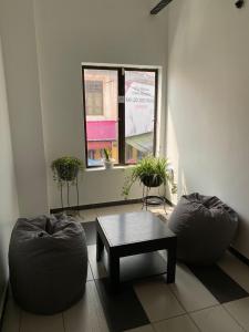 a living room with two chairs and a table and a window at Marina Hostel in Ipoh