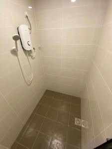 a bathroom with a shower with a toilet paper dispenser at Marina Hostel in Ipoh