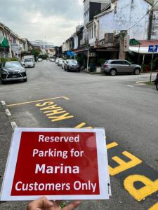 a sign that reads reserved parking for marina customers only at Marina Hostel in Ipoh