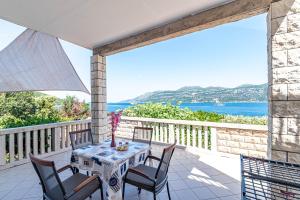 un tavolo e sedie su un balcone con vista sull'oceano di Apartments by the sea Tri Zala, Korcula - 9237 a Korčula