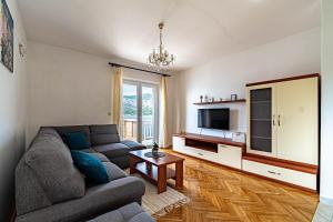a living room with a couch and a tv at Apartments by the sea Tri Zala, Korcula - 9237 in Korčula