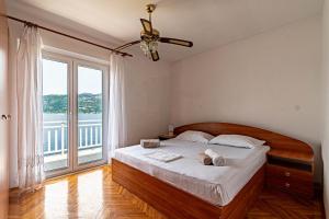 a bedroom with a bed and a large window at Apartments by the sea Tri Zala, Korcula - 9237 in Korčula