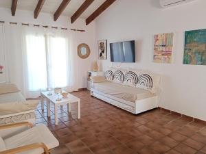 sala de estar con muebles blancos y TV de pantalla plana en "PARAÍSO 14" Espectacular casa con terrazas, piscina y vistas al mar, en Son Xoriguer
